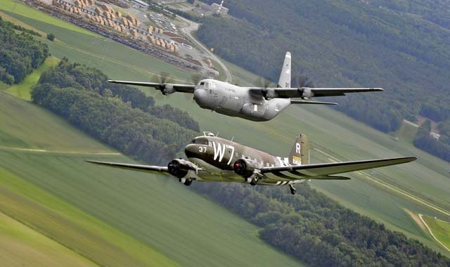 A Douglas C-47 Skytrain, known as Whiskey 7, flies alongside a C-130J Super Hercules from the 37th Airlift Squadron May 30 over Germany. The C-47 came to Ramstein for a week to participate in base activities with its legacy unit, the 37th Airlift Squadron, before returning to Normandy to recreate its role and drop paratroopers over the original drop zone in Sainte-Mere-Eglise, France.