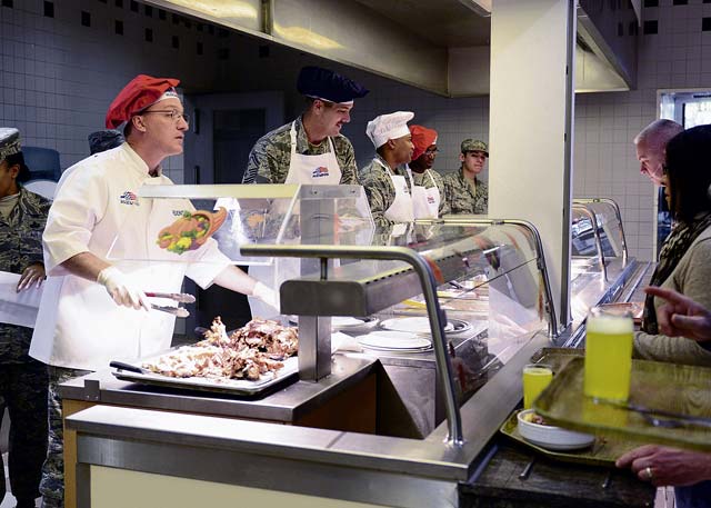 Brig. Gen. Patrick X. Mordente, 86th Airlift Wing commander, serves turkey to KMC members on Thanksgiving Day at the Rheinland Inn Dining Facility. Mordente and several other leaders  volunteered to help serve a Thanksgiving meal for KMC Airmen and their families. 