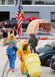 Sgt. Erick Galkowski (in blue), a chemical, biological, radiological and nuclear survey team member with the 773rd Civil Support Team, 7th Civil Support Command, assists Belgian firefighters in mitigating and containing a mock chemical spill during a joint exercise June 2 to 8.