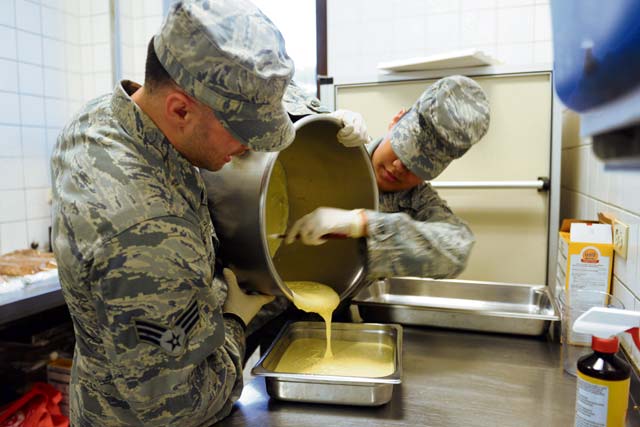 Senior Airman Jonathan DaSilva, 786th Force Support Squadron food service journeyman, and Airman 1st Class Jalyssa Holman, 786th FSS server apprentice, pour cake batter into a container at the Rhineland Inn Dining Facility. The Rhineland Inn Dining Facility has staff on shift 24 hours a day to ensure food is ready for the Airmen they are serving throughout the day.
