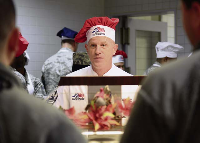 Chief Master Sgt. Frank Batten III, 86th Airlift Wing command chief, asks Airmen if they would like roast beef on Thanksgiving Day at the Rheinland Inn Dining Facility. The Thanksgiving meal provided Airmen with a taste of home while separated from their families.