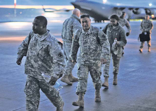 Soldiers from the 21st Theater Sustainment Command headquarters, 7th Civil Support Command, 30th Medical Brigade and 16th Sustainment Brigade walk toward a C-17 aircraft bound for Dakar, Senegal, Nov. 17.
