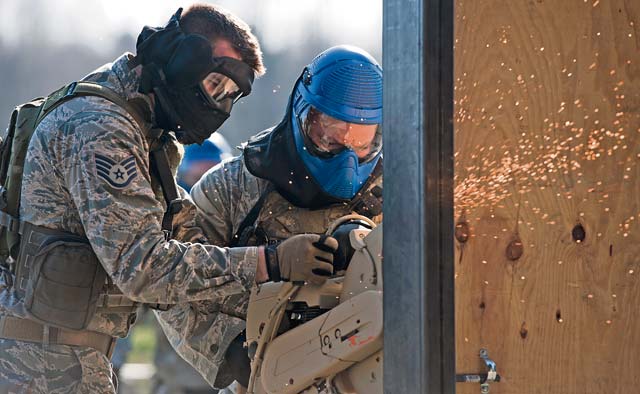 Photo by Senior Airman Damon KasbergStaff Sgt. Cliff Coppenbarger (left), 435th Security Forces Squadron cadre, helps Staff Sgt. Brandon Burress, 701st Munitions Support Squadron custody forces member, breach a door during the Battlefield Leaders Assaulters Course March 11, 2014, on Ramstein.