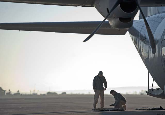 Airman 1st Class Andrew Bracamontes (left) and Senior Airman Matthew Howard, Ramstein Fly Away Security Team members, double check equipment prior to boarding a C-130J Super Hercules at Sigonella Naval Air Station, Italy. F.A.S.T. members provided security for the Airmen of the 37th Airlift Squadron during a mission to Central African Republic, Africa.