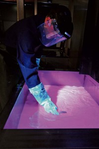 Staff Sgt. Joshua Paserba, 86th Maintenance Squadron  nondestructive inspection technician, performs a step in the penetrant inspection process, July 31 on Ramstein.  This part in the process uses an emulsifying bath, which removes traces of excess penetrant, allowing crack indications to be more readily visible.