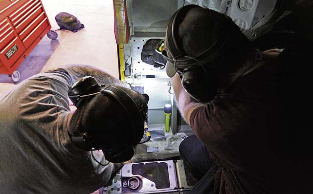 Zach Edens (left) and Joel Rykard, 560th Aircraft Maintenance Squadron mechanics from Robbins Air Force Base, Ga., prepare a C-130J Super Hercules to be compatible for a new  seat.