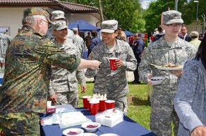 A member of the German army reserve unit hands Pfc. Linda Castillo a bowl of cabbage salad during the “Thank You Wounded Warriors” luncheon June 14 at the USO Warrior Center on Wilson Barracks.