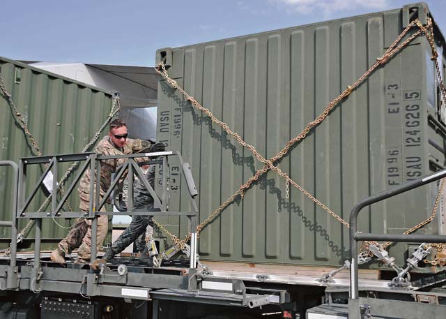 MIHAIL KOGALNICEANU, Romania — Sgt. Robert Epley, a truck driver with the 2nd Cavalry Regiment and a native of Morganton, N.C., helps push a TRICON container onto a cargo lifter prior to it being loaded onto a Boeing 747 cargo jet here, July 14. The 21st Theater Sustainment Command, along with the 627th Movement Control Team, 16th Sustainment Brigade and the Air Force’s 435th Contingency Response Group moved more than 200 TRICON containers into Afghanistan for the 2nd Cavalry Regiment, taking nine round trips by two B-747s.  