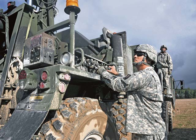 Staff Sgt. Sung Lee, a mechanic with the 21st Theater Sustainment Command’s 18th Combat Sustainment Support Battalion, 16th Sustainment Brigade, operates the controls of a crane while trying to recover an overturned vehicle during the Wheeled Vehicle Recovery Course Sept. 19. Twenty Soldiers from the 21st TSC participated in the training to learn how to recover stuck and rolled vehicles as well as how to safely tow them long distances.