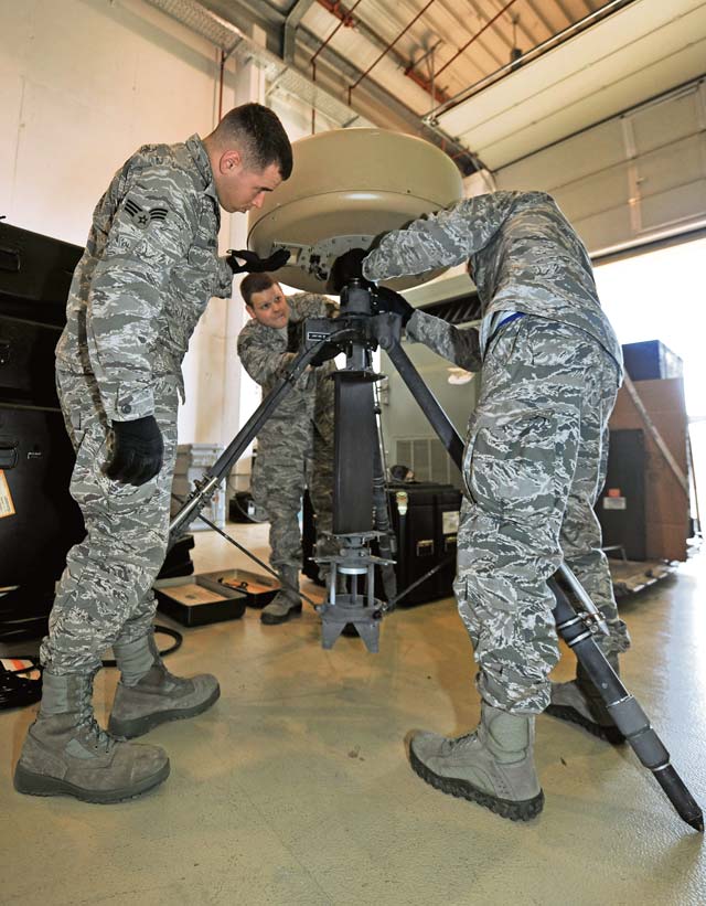 Senior Airman Steven Rogers and Staff Sgts. Jared Ulmer and Dylan Gaudette, 1st Combat Communications Squadron airfield systems technicians, deploy the mobile Tactical Air  Navigation System. The 1st CBCS provides bare airfield communications, weather information and navigational support to assist aircraft in navigation and landing.