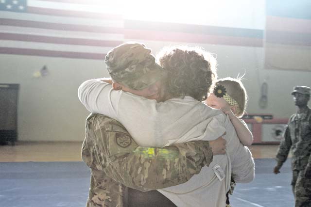 Spc. Kevin Floyd, 212th Combat Support Hospital health care specialist, 30th Medical Brigade, 21st Theater Sustainment Command, hugs his wife and children at a welcome home ceremony April 6 at the Miesau Ammo Depot following a nine-month deployment to the Afghan National Detention Facility in Parwan, Afghanistan.