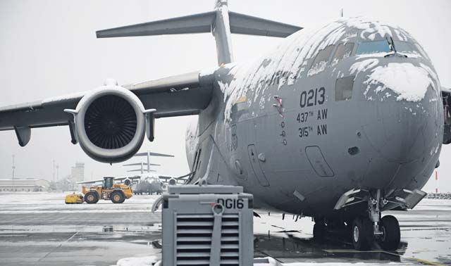 A C-17 Globemaster III sits on the Ramstein flightline Dec. 3 as civil engineers clear the ramp after the first snowfall of the season. The 786th Civil Engineer Squadron heavy equipment shop came in early in the morning to ensure Ramstein can keep launching aircraft. 