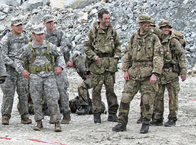 U.S. Army Soldiers Sgt. 1st Class Jason Rizzi (left), civil affairs operations NCOIC, Company A, 457th CA Battalion, 361st CA Brigade, 7th Civil Support Command; Sgt. 1st Class  Michael Kennicker (center left), first sergeant, Co. A, 457th CA Bn., 361st CA Bde., 7th CSC; and Staff Sgt. David Heath (rear left), civil affairs NCO, Co. A, 457th CA Bn., stand next to British service members as they all receive range instructions during the “Lombardia 2013” international patrolling competition May 25.  