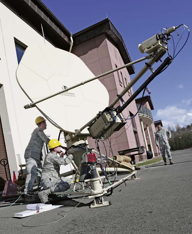 Staff Sgt. Kristopher Jaynes (right) and Senior Airman Jeffrey Bishop, 1st Combat Communi-cations Squadron tactical communications technicians, inspect a satellite dish March 3 on Ramstein.