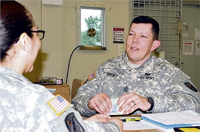 Spc. Joan Bazan, pay analyst with the 106th Financial Management Support Unit, issues casual pay to Sgt. Maj. Johnny Valdez, Sustainment Task Force 16 sergeant major, March 10 at Mihail Kogalniceanu Air Base in Romania.