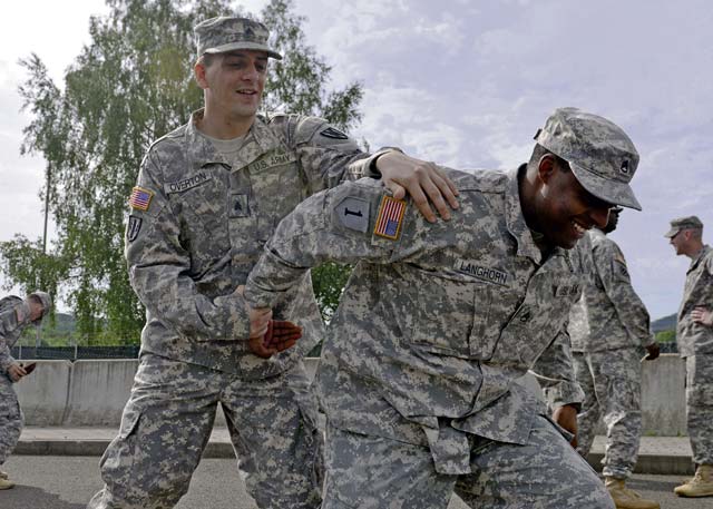 Sgt. Joshua Overton, human resources NCO with the 21st Theater Sustainment Command, practices unarmed self-defense techniques on Staff Sgt. Fredrick Longhorn, HR NCO with the 21st TSC, during guard force training May 21 on Rhine Ordnance Barracks.
