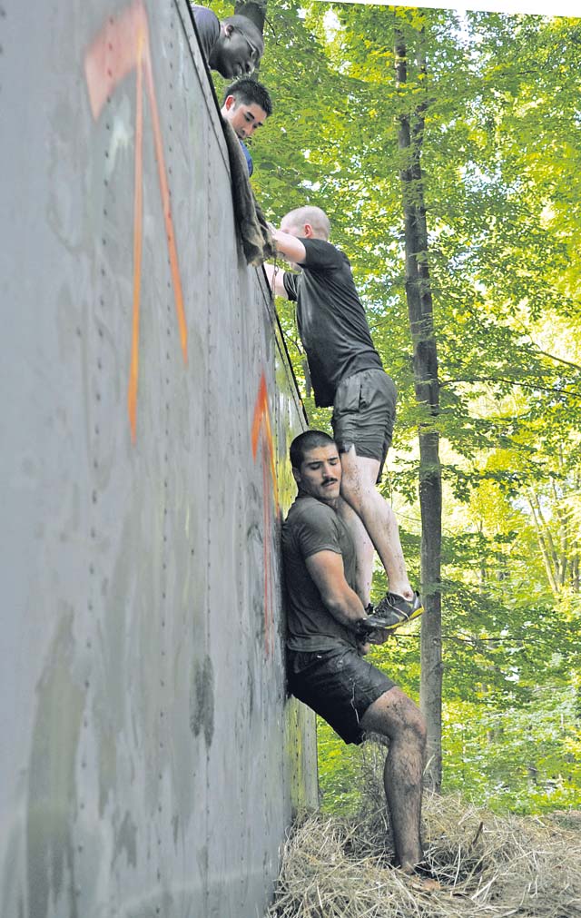 A Mudless Mudder team helps each other over an obstacle. The obstacles consisted of a low-crawl, hay bales, a tightrope, a tire hill and dunk tanks, among others.