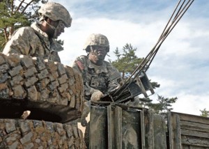 Sgt. Ray Christian (right), a mechanic with the 21st Theater Sustainment Command’s Headquarters and Headquarters Company, and Pfc. Tyrone Wheeler (left), a mechanic with the 21st TSC’s 18th Engineer Brigade, prepare to hook a crane head onto an overturned vehicle during the Wheeled Vehicle Recovery Course Sept. 19.
