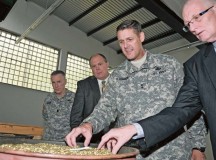 Maj. Gen. John R. O’Connor, commanding general of the 21st Theater Sustainment Command, examines brass granules that were broken down by a brass granulator machine during a visit to the Ammunition Center Europe Oct. 17 at Miesau Army Depot.