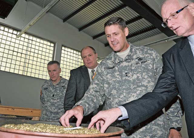Maj. Gen. John R. O’Connor, commanding general of the 21st Theater Sustainment Command, examines brass granules that were broken down by a brass granulator machine during a visit to the Ammunition Center Europe Oct. 17 at Miesau Army Depot.
