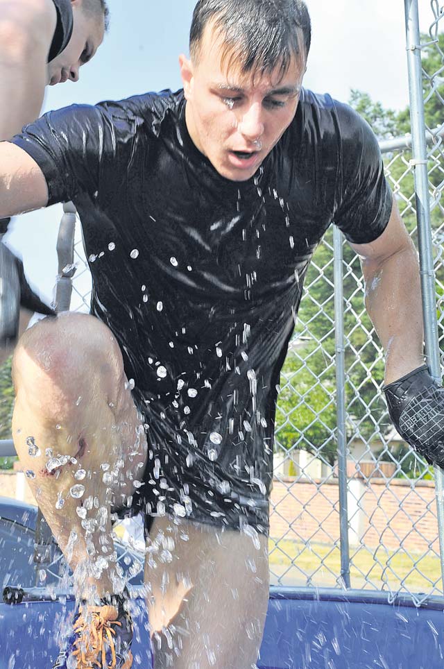 A participant jumps in and out of the first obstacle — a cold water dunk tank. Participants formed small teams to compete in the Mudless Mudder. 