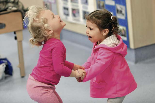 Kylie, daughter of Senior Airman Kyle Holmes, and Virginia, daughter of Tech. Sgt. Paul Piper, dance together during playtime at the Child Development Center Jan. 10. With few spots available at any given time, parents should make sure they register their children at the CDC as soon as possible.