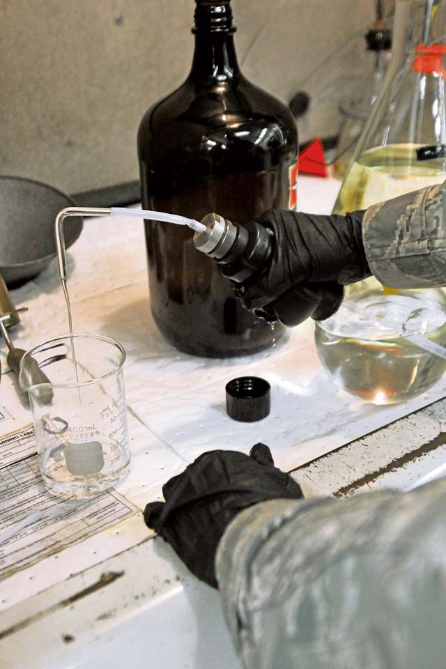 Airman 1st Class Sophia Finch, 86th Logistics Readiness Squadron laboratory technician,  measures filtered petroleum ether to clean a fuel sampling bottle during the bottle method test Aug. 15 on Ramstein. The filtered petroleum ether is designed to remove fuel residue and  prepare sampling equipment for the next analysis.