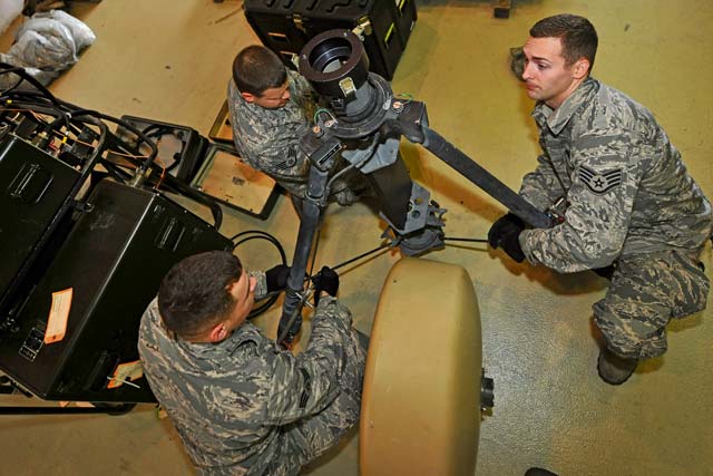 Senior Airman Steven Rogers and Staff Sgts. Jared Ulmer and Dylan Gaudette, 1st Combat Communications Squadron airfield systems technicians, deploy the mobile Tactical Air Navigation System. The 1st CBCS airfield systems flight participates in annual exercises and  missions throughout Europe, Asia and Africa in support of joint operations between multi-service nations.