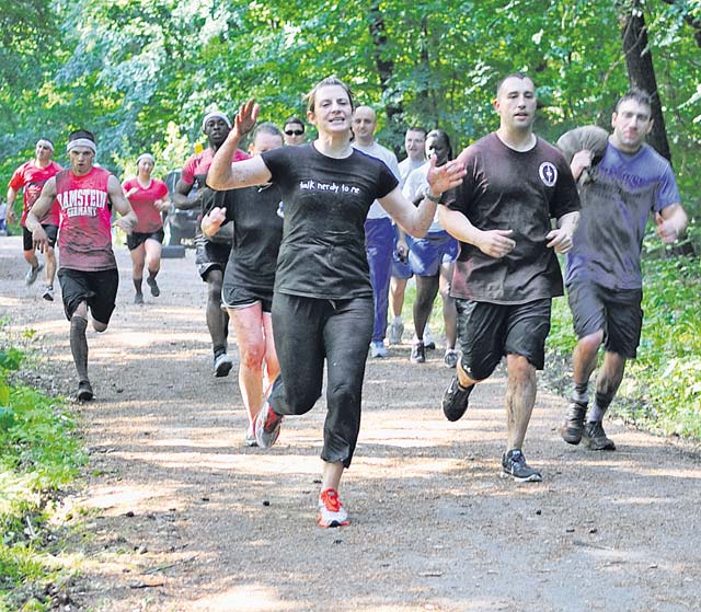 Participants cheer as they run to the next obstacle during the Mudless Mudder June 19 on Ramstein. Participants competed for first, second, third and last places, as well as best costume.