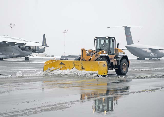 Airmen from the 786th Civil Engineer Squadron plow the remaining snow off the flightline after receiving the first snow of the season Dec. 3. The 786th CES heavy equipment operators plow, brush and keep the runways, taxiways and ramps clear to ensure mission success no matter the weather.