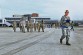 Members of the 721st Aerial Port Squadron spread out across the flightline to conduct a foreign object damage prevention walk.