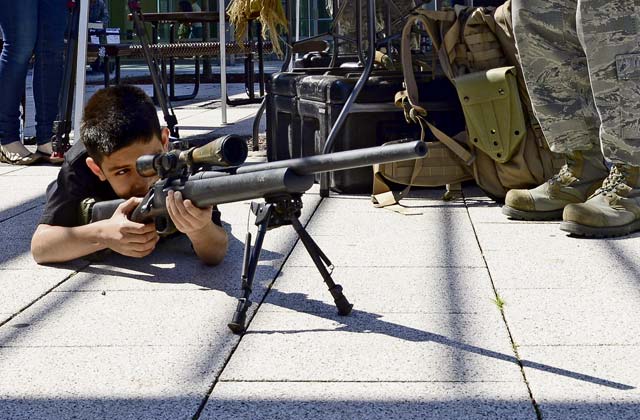 Adrian Vasquez, son of Tech. Sgt. Rigo Vasquez, U.S. Air Forces in Europe Kisling NCO Academy instructor, looks down the scope of a rifle during the 86th SFS Police Week display May 17 on Ramstein.