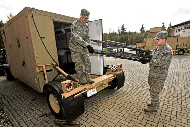 Staff Sgts. Dylan Gaudette and Jared Ulmer, 1st Combat Communications Squadron airfield  systems technicians, unload a mobile Tactical Air Navigation System antenna tripod for an upcoming deployment Nov. 13 on Ramstein.