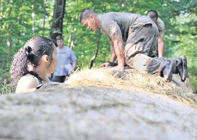 Participants climb over a hay bale obstacle during the Mudless Mudder June 19 on Ramstein. Teams were rated on the amount of time it took to get through the course as well as the number of penalties received during each obstacle.