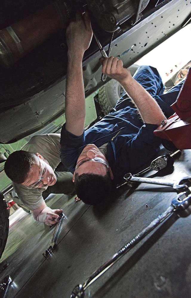 Airmen 1st Class Lorne Abshire (right) and Brock Taczak, 86th Vehicle Readiness Squadron light vehicle mechanics, loosen the bolts from the transmission of a Humvee.