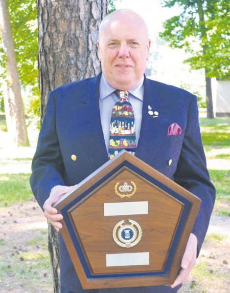 Eric Leader poses for a photo with an Air Force award he received.