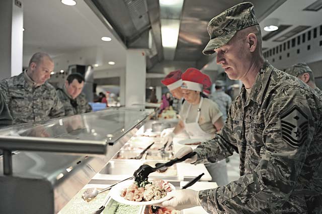Master Sgt. Jay Peavley, 435th Construction and Training Squadron first sergeant, helps serve food to Airmen and their families at the Rheinland Inn Dining Facility.