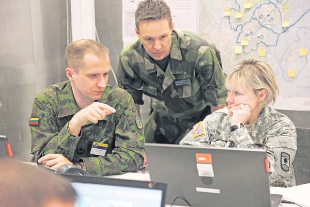 From left, Lithuanian army Maj. Gediminas Latvys, Baltic Defense College student, and Swedish army Capt. Erik Ruhmann, Swedish National Defense College student, conduct civil affairs planning with Army Sgt. 1st Class Janice Watterson, civil affairs NCO, 361st Civil Affairs Brigade, 7th Civil Support Command, April 2 during Viking 14, a command post exercise hosted by the Swedish armed forces. 
