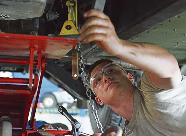 Airman 1st Class Brock Taczak, 86th Vehicle Readiness Squadron light vehicle mechanic,  attaches a jack to a Humvee before removing the transmission.
