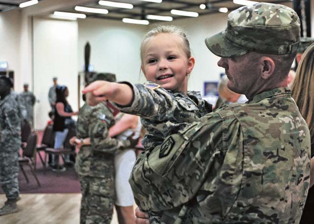 Taylor Lynn Myatt points to a welcome home sign she made for her father, Sgt. Carl T. Myatt, movement control NCO assigned to the 21st Theater Sustainment Command’s 1177th Movement Control Team, 7th Civil Support Command, during a redeployment ceremony Monday at the Kaiserslautern Community Activity Center on Daenner Kaserne. The 1177th MCT returned after a nine-month deployment to Afghanistan.