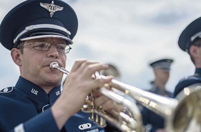 A U.S. Air Forces in Europe and Air Forces Africa Band trumpet player plays the German national anthem while the flag is lowered during a retreat ceremony on Ramstein.