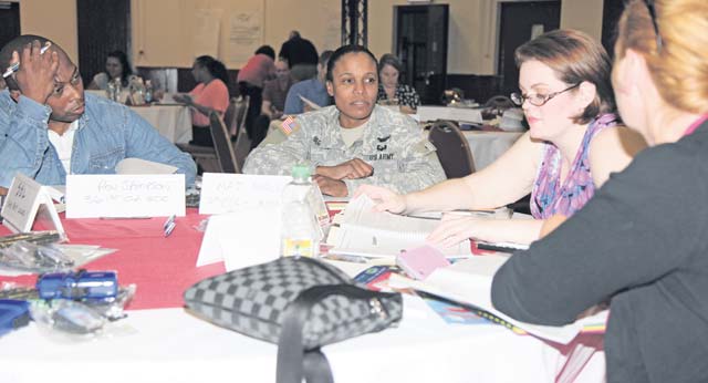 Left to right, Ron Sampson, family readiness group leader, 361st Civil Affairs Brigade, 7th Civil Support Command and a resident of Frankfurt, Germany; Maj. Kedra Segler, the medical readiness liaison officer, Medical Support Unit-Europe, 7th CSC and unit family readiness liaison and a New York native ; Sugin Musgrave a volunteer with the 7th CSC Headquarters and Headquarters Company, Family Readiness Group and a native of Detroit and Anja Seidl the FRG leader for HHC, 7th CSC and a native of Erlangen, Germany look over materials Aug. 2 in the Kaiserslautern Community Activities Center during an Army Reserve Family Programs-led FRG conference and training event titled:  “Training for FRGs in a New Era.”