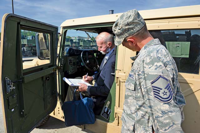 Retired Chief Master Sgt. Gerald Richards, 1st Combat Communication Squadron alumnus, and Master Sgt. Dana Leonard, 1st CBCS plans and  support director, take a look into a HUMVEE Aug. 15 on Ramstein. 