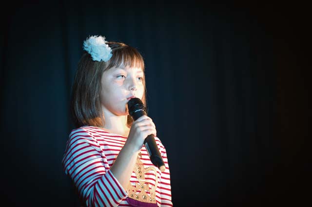 Sadie Fine, daughter of Master Sgt. Chet Fine, 1st Communications Maintenance Squadron operations flight chief, sings during a talent contest.