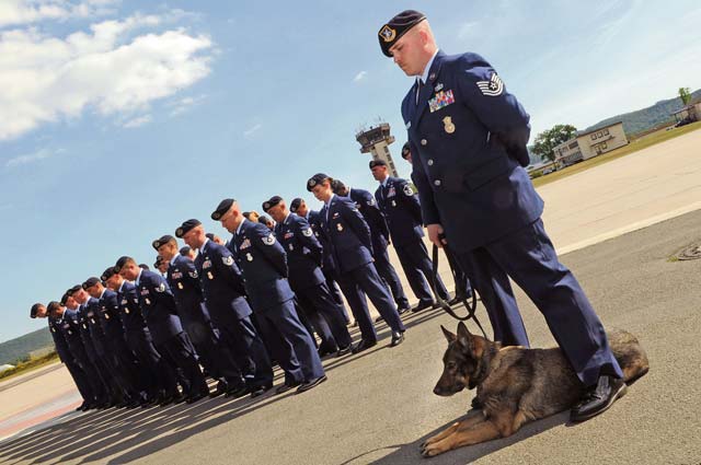 Photo by Staff Sgt. Tyrona Lawson Tech. Sgt. Kyle Richards, 86th Security Forces Squadron military working dog handler, stands with MWD Omega as the security forces prayer is recited during Police Week May 13, 2011, on Ramstein. A retreat and final mount guard will be held today.