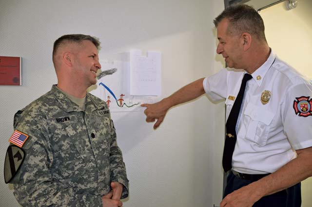 Lt. Col. George Brown, U.S. Army Garrison Kaiserslautern’s director of emergency services, and Garrison Fire Chief Jürgen Stegner look at art work from local school children May 7 hung in the hallways of the DES headquarters building on Rhine Ordnance Barracks in Kaiserslautern. Brown sent a request to the children to provide drawings to decorate the area.