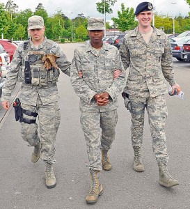 Photo by Airman 1st Class Dymekre Allen Senior Airman Marvin Wigfall, 86th Airlift Wing Public Affairs broadcaster, is escorted to the holding area.