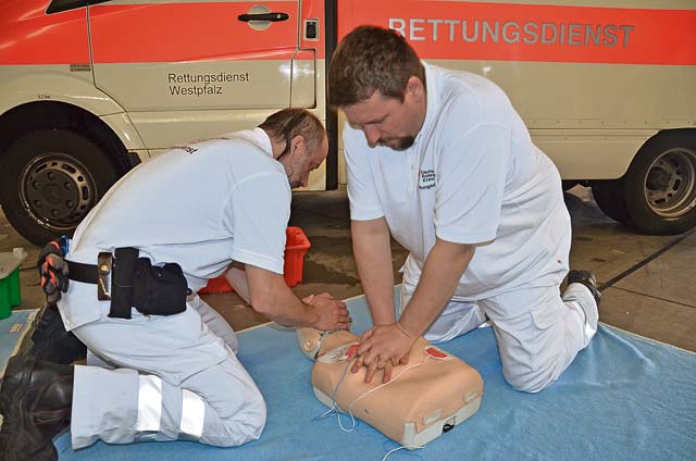 Alexander Jung (right) and Steffen Rothlander, members of the  German Red Cross, conduct CPR training during the garrison’s annual summer safety day May 7 on Rhine Ordnance Barracks in Kaisers-lautern.