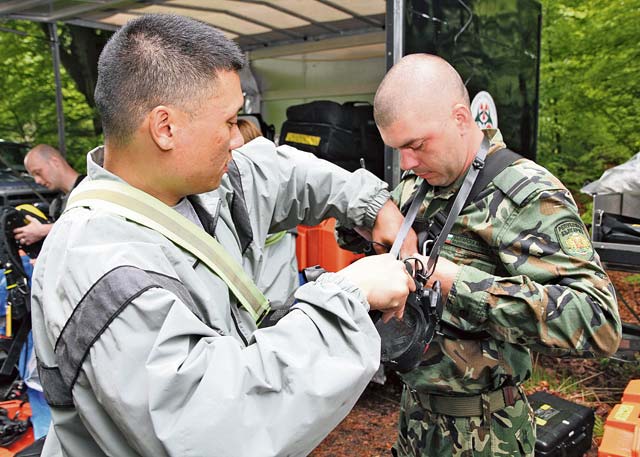 Cpl. Eric J. Song, a survey team member with the 773rd Civil Support Team, 21st Theater Sustainment Command’s 7th Civil Support Command, assists Bulgarian army Sgt. Peter Evgeniev Dzhongov with a self-contained breathing apparatus during partnership training May 14 to 18.