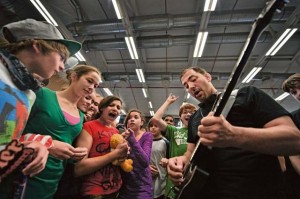 Musician Dereck McKeith performs while surrounded by students May 21 at Ramstein Middle School. The Traveling Guitar Foundation embarked on its first USO tour of Germany. 